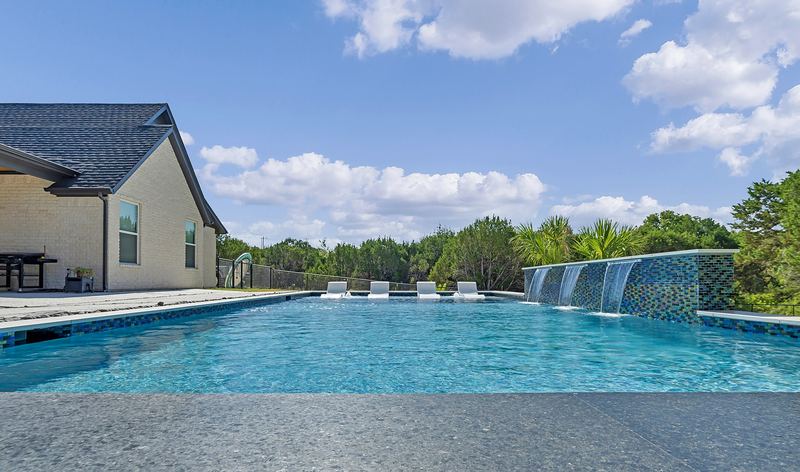 Gunite pool with a glass tile sheer descent wall